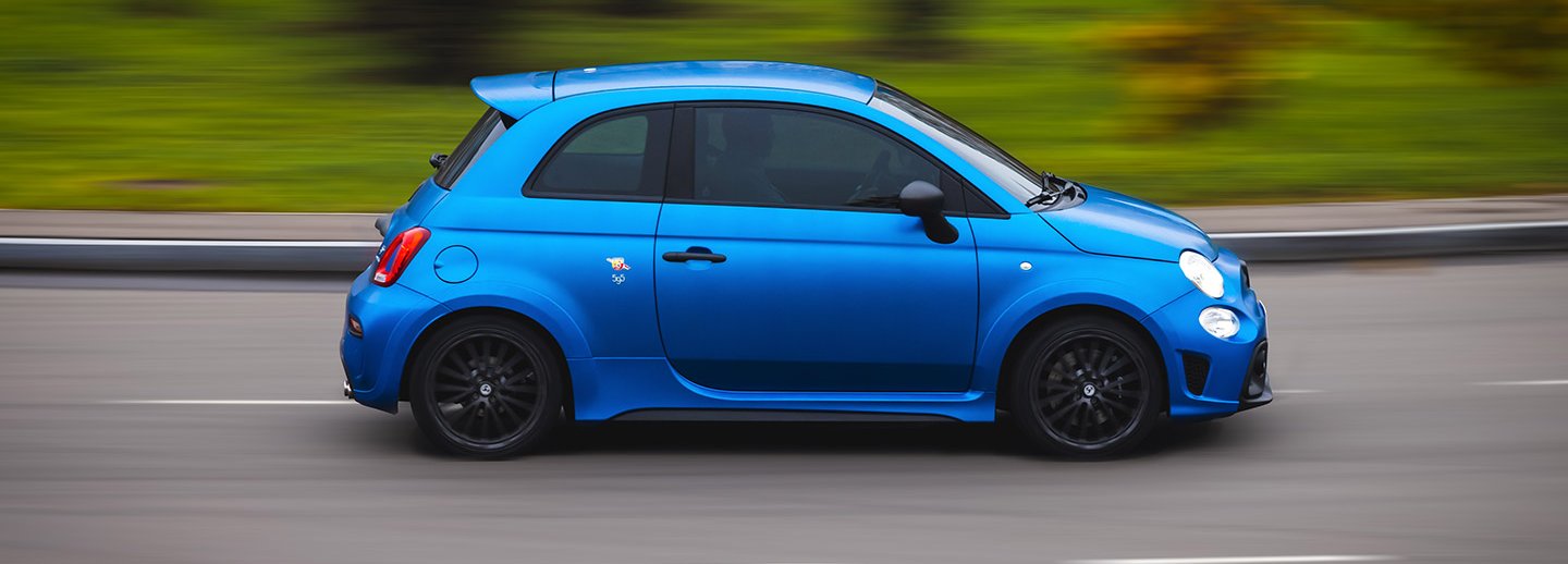 Abarth 595 competizione driving down a road